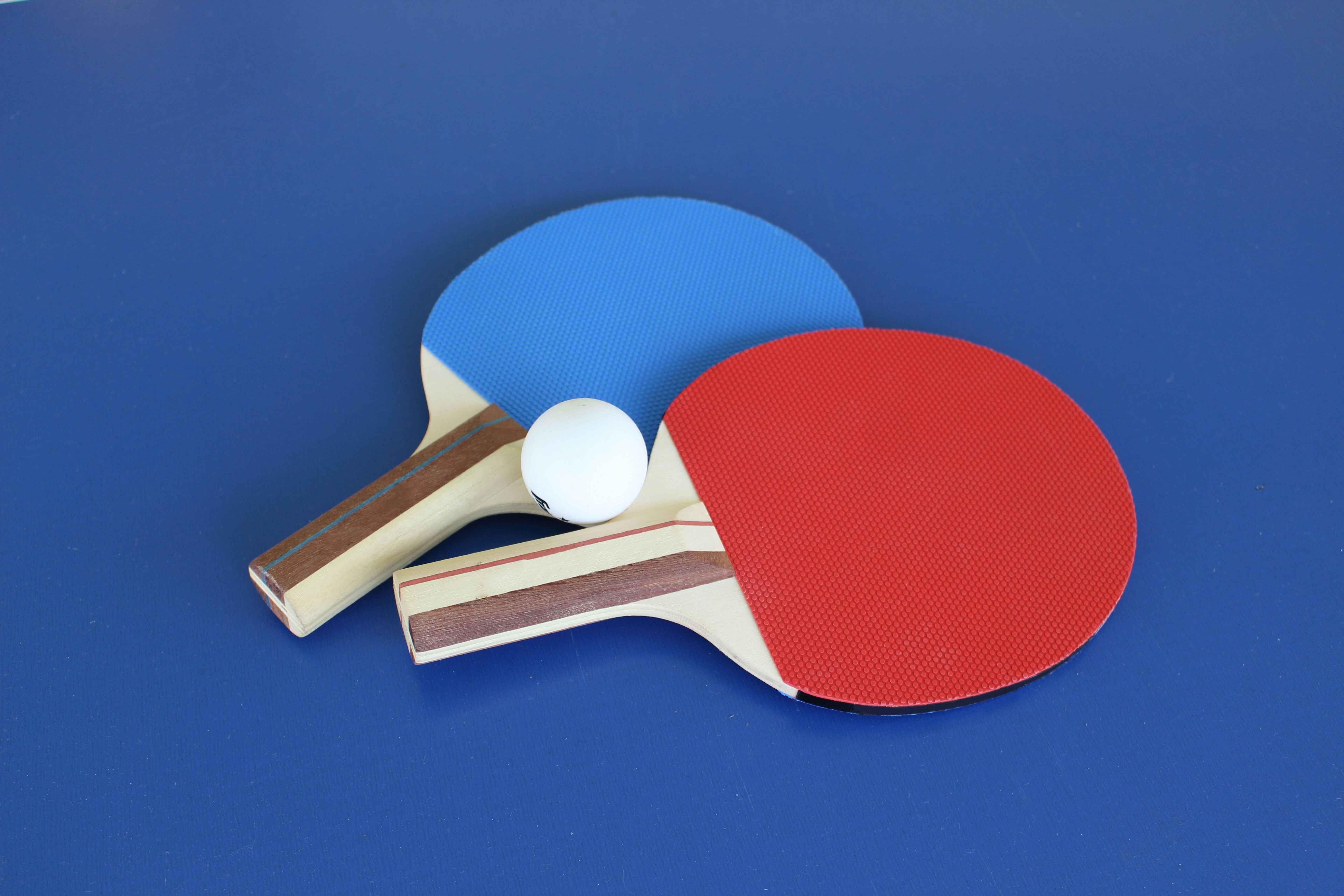 blue and red pong paddles with a white ball; Credit: @Lisa Keffer on Unsplash